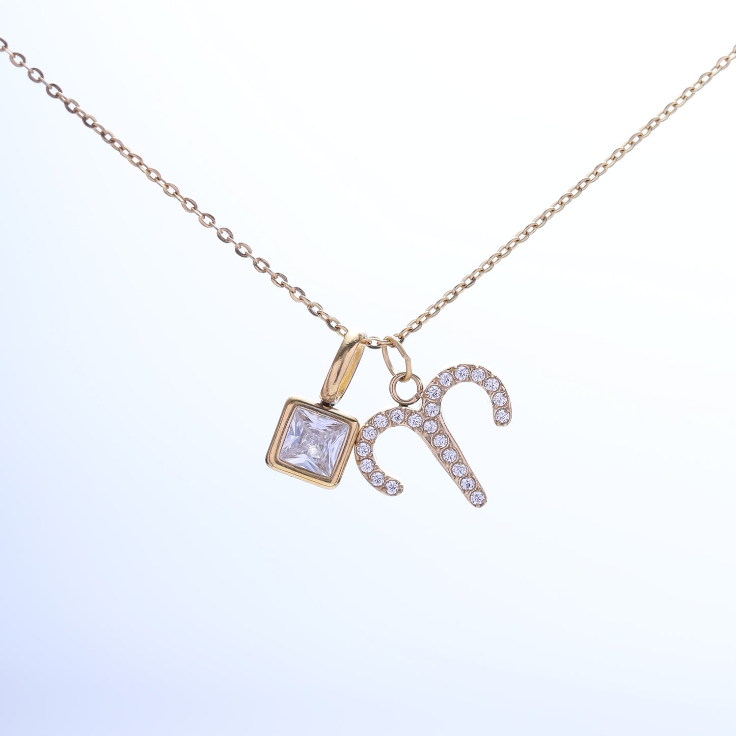 Close-up of the Aries zodiac necklace, featuring a sparkling zodiac charm and a birthstone on a gold-plated chain.