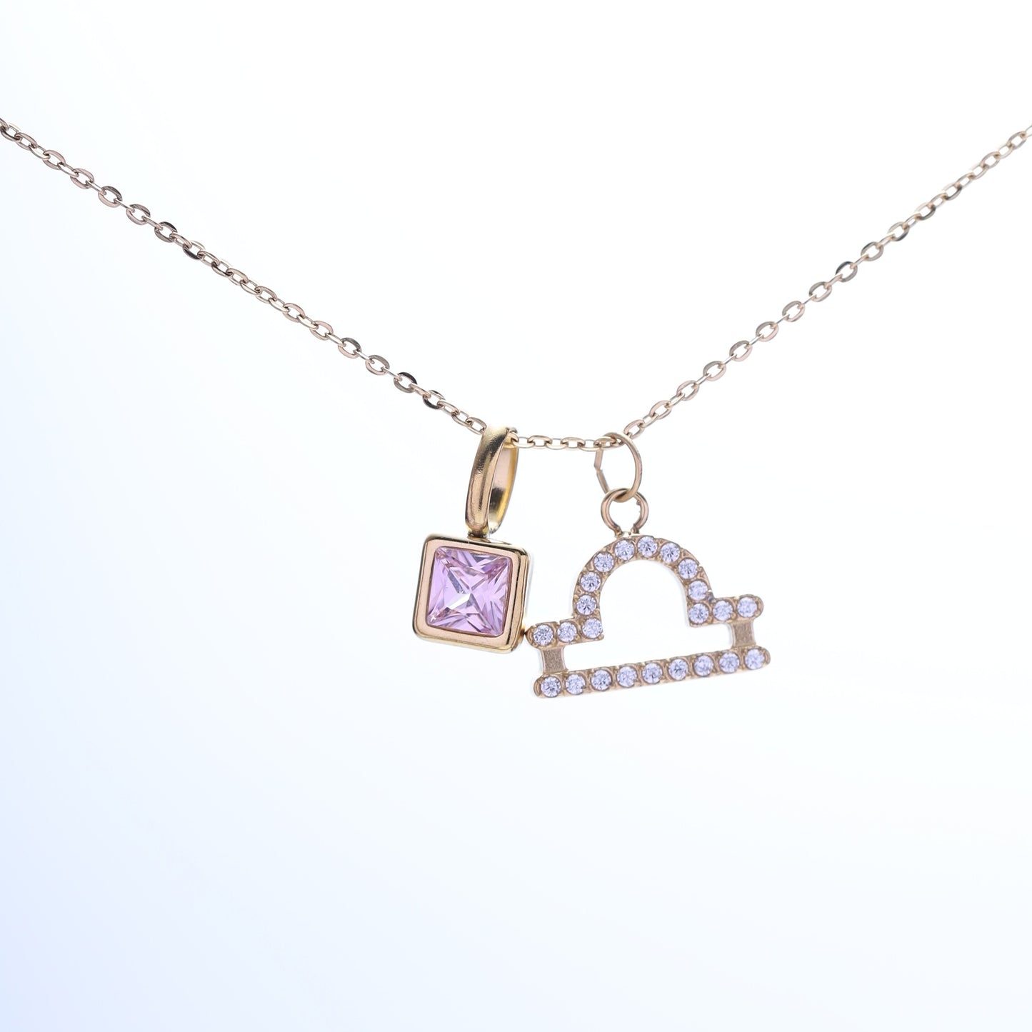Libra zodiac necklace with an October birthstone (pink tourmaline cubic zirconia) and a gold-plated charm.