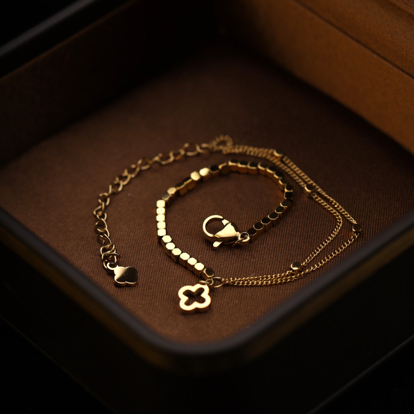 Bracelet displayed flat in jewelry box showing chain and charm layout.