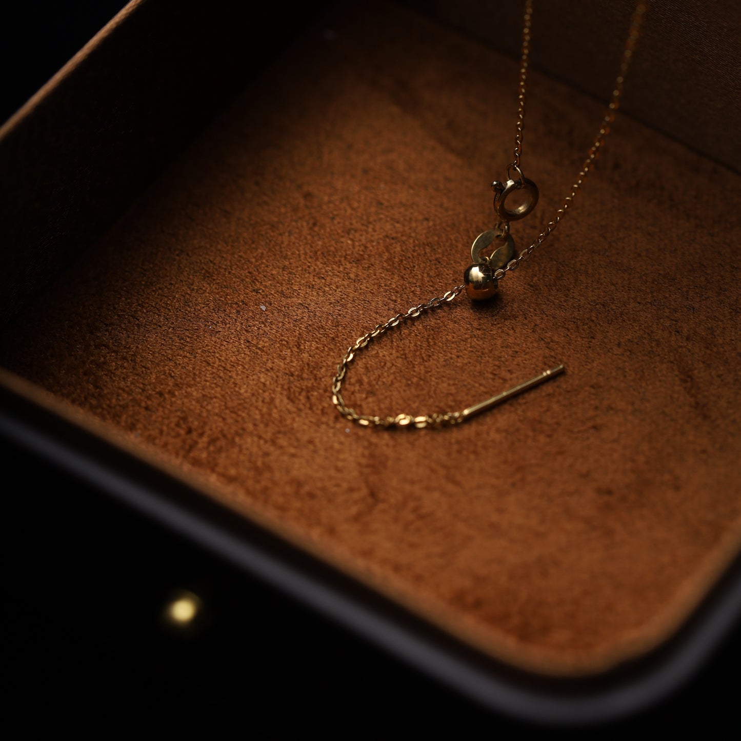 A close-up of a gold Aquarius necklace with an adjustable sliding chain (18-inch max) and two gemstone charms.