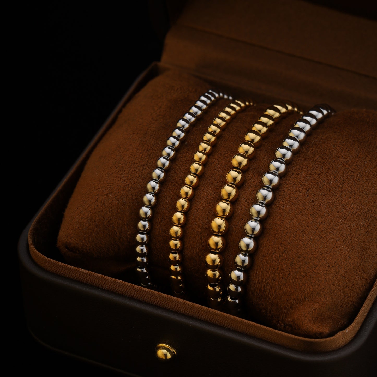 Close-up of silver and gold beaded bracelets with shiny finish