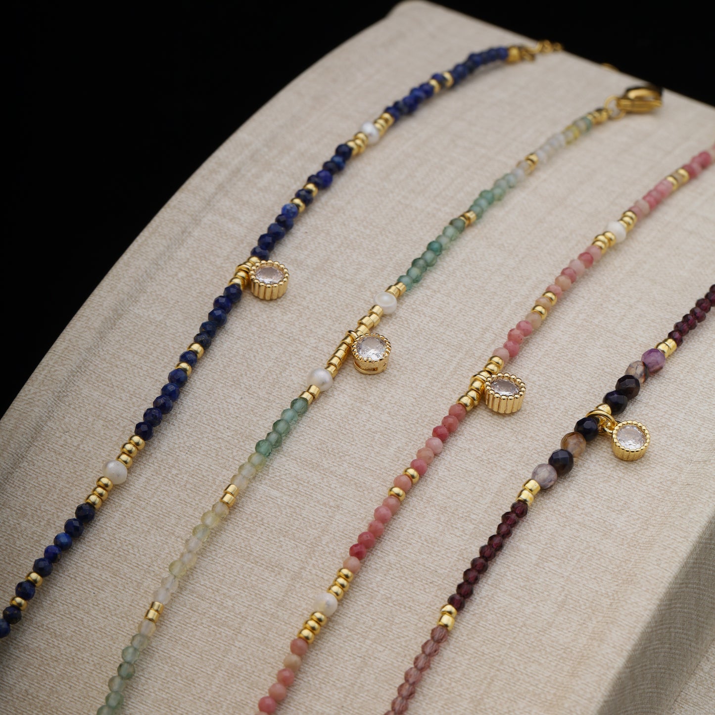 Bracelets displayed flat on a fabric stand to show gemstone color variations.