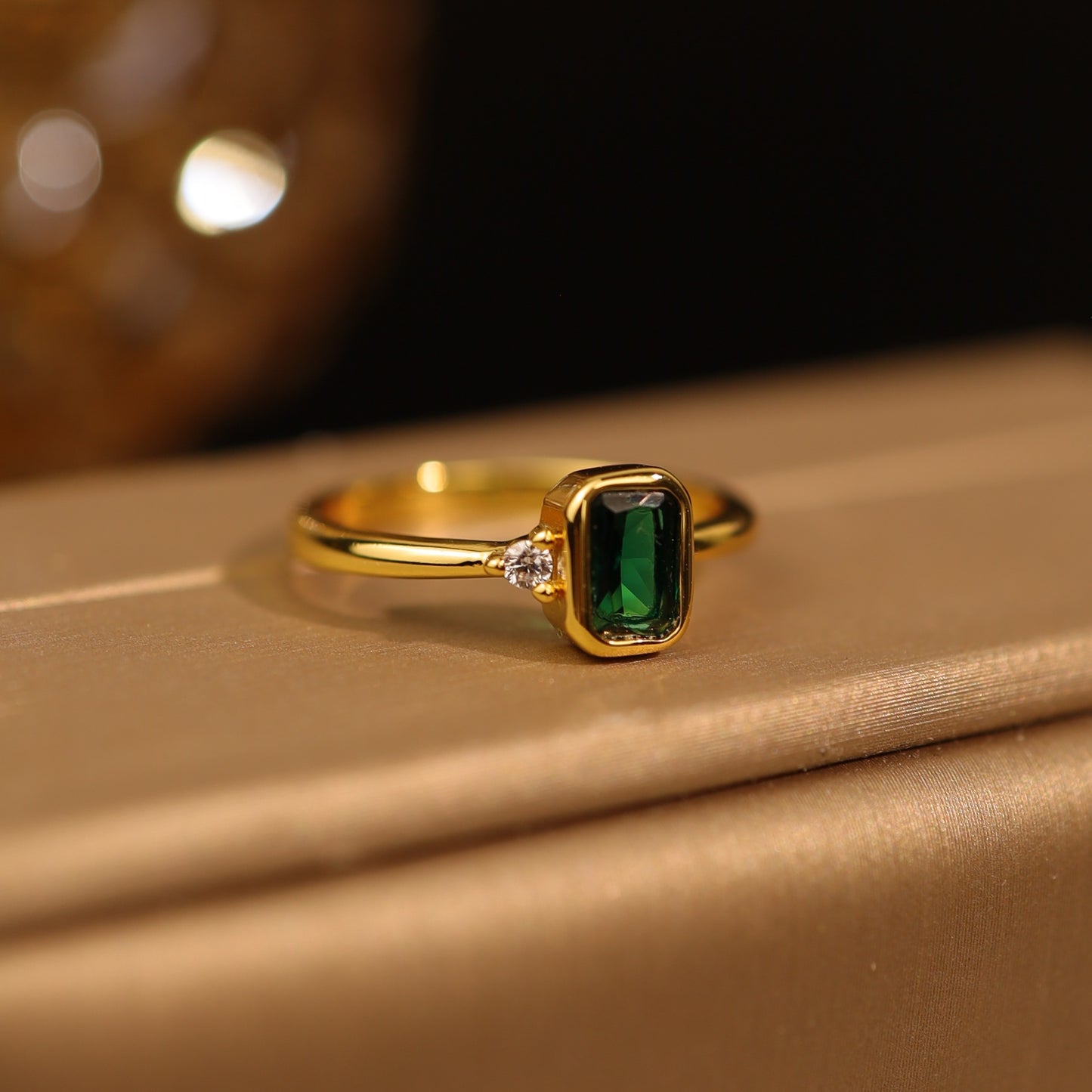 Gold-plated ring with emerald green gemstone and cubic zirconia – front view