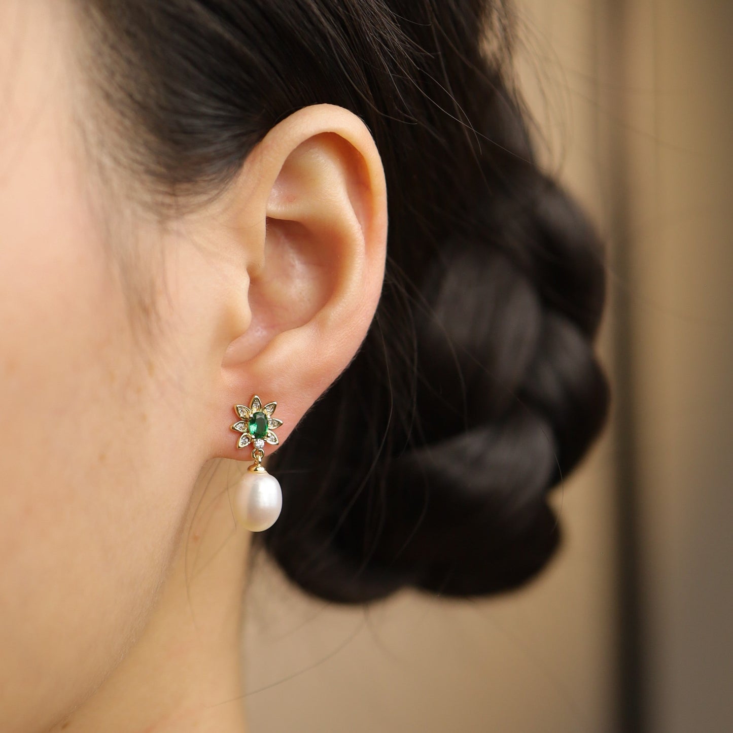 A model wearing emerald green freshwater pearl earrings, highlighting their delicate floral design.