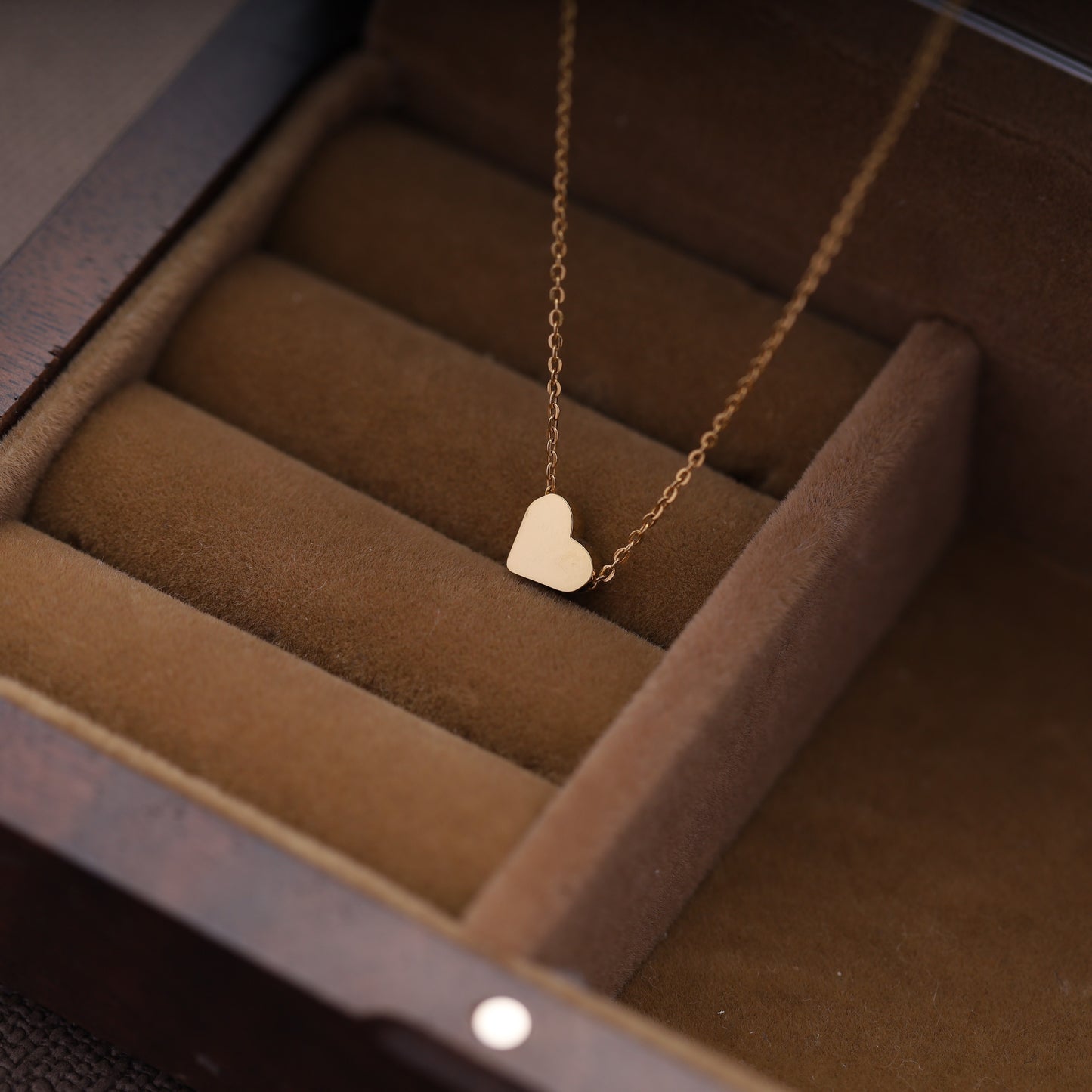 Minimalist heart necklace displayed in a luxury jewelry box, available in gold and silver.