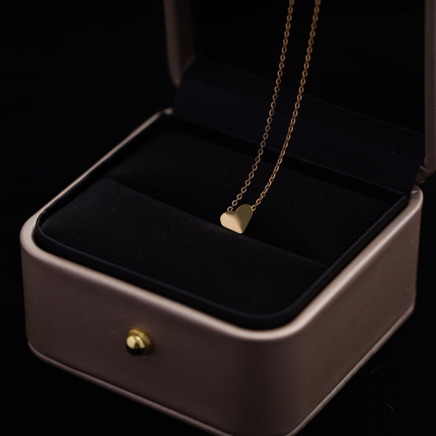 gold stainless steel heart necklace featuring an adjustable sliding mechanism.