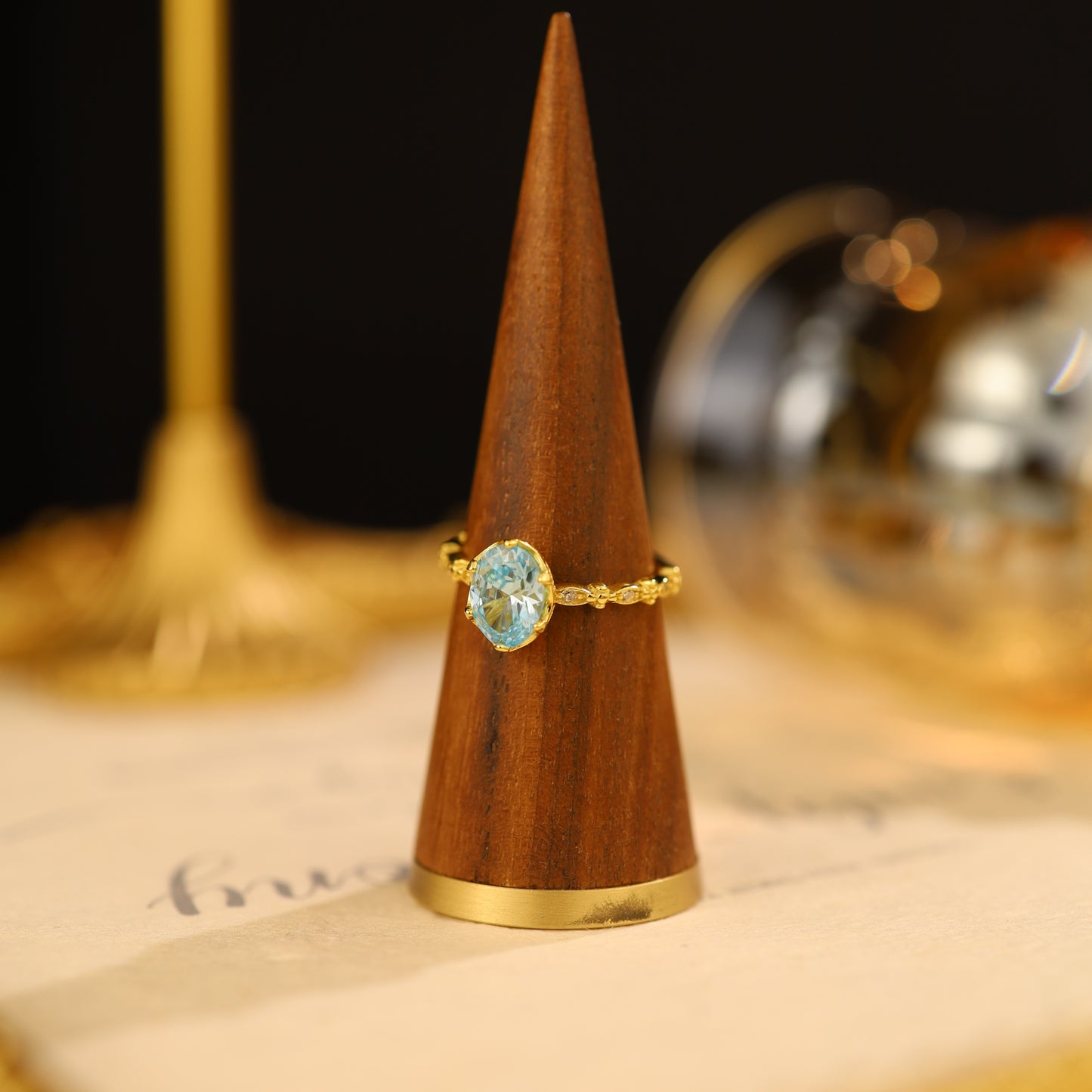 A close-up of a sterling silver adjustable ring with intricate gold-plated detailing.