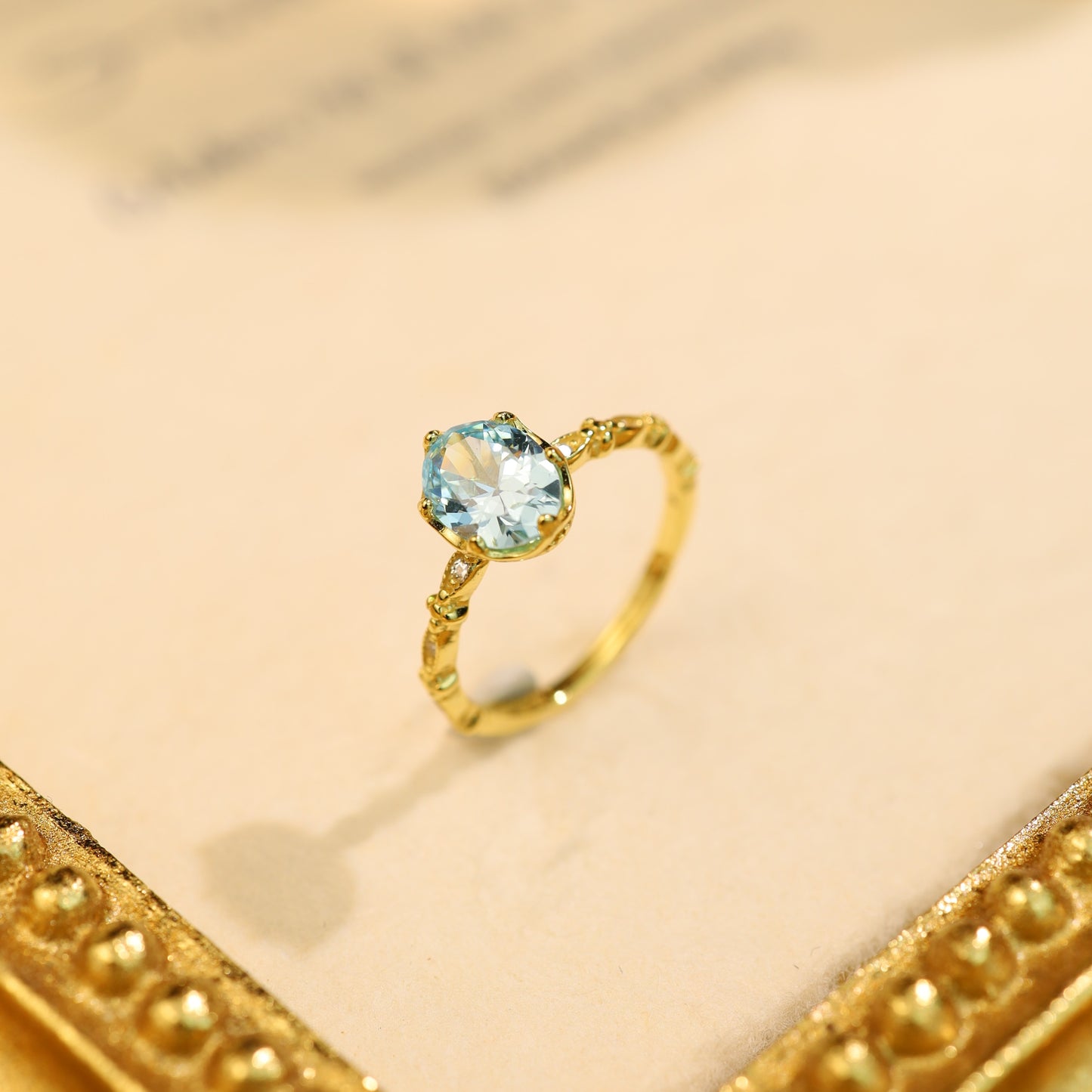 A sterling silver adjustable blue gemstone ring, elegantly displayed on a vintage gold frame.