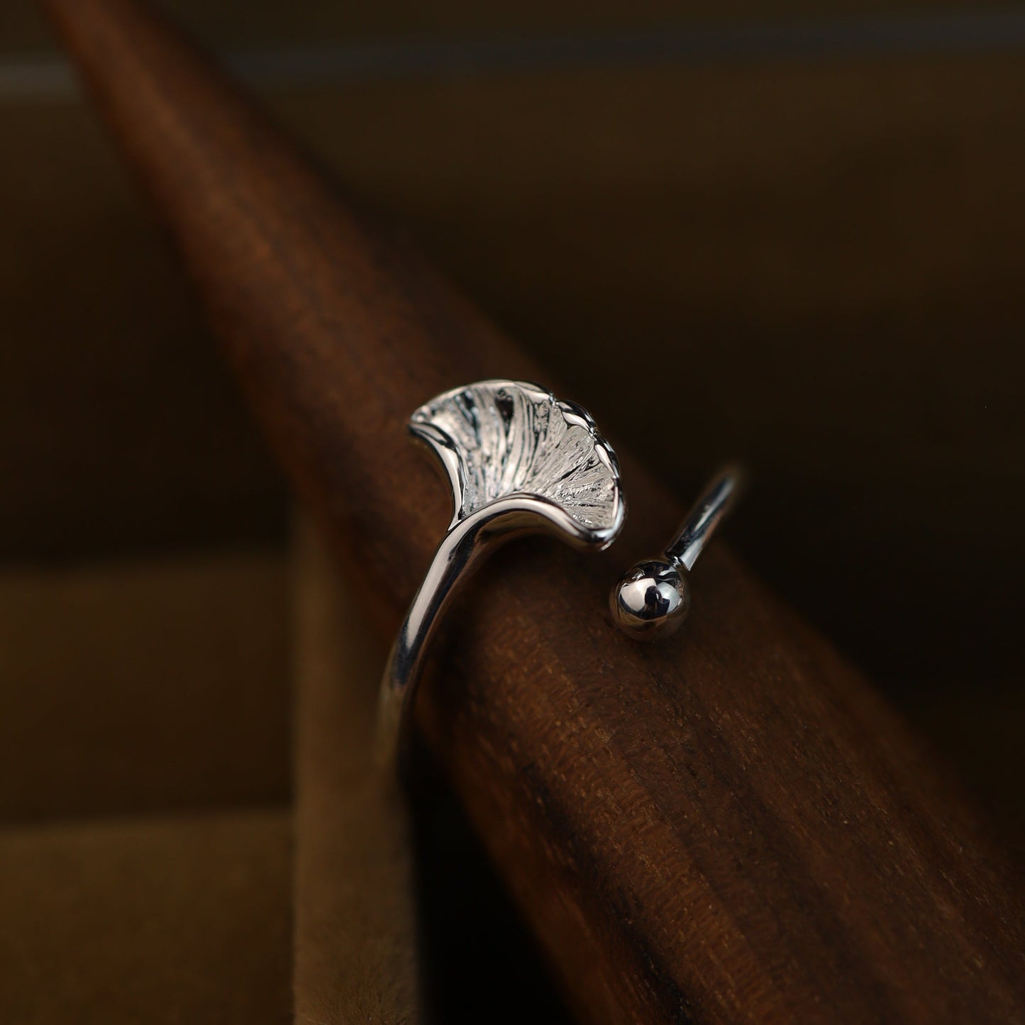Ginkgo leaf ring displayed on a wooden ring cone.