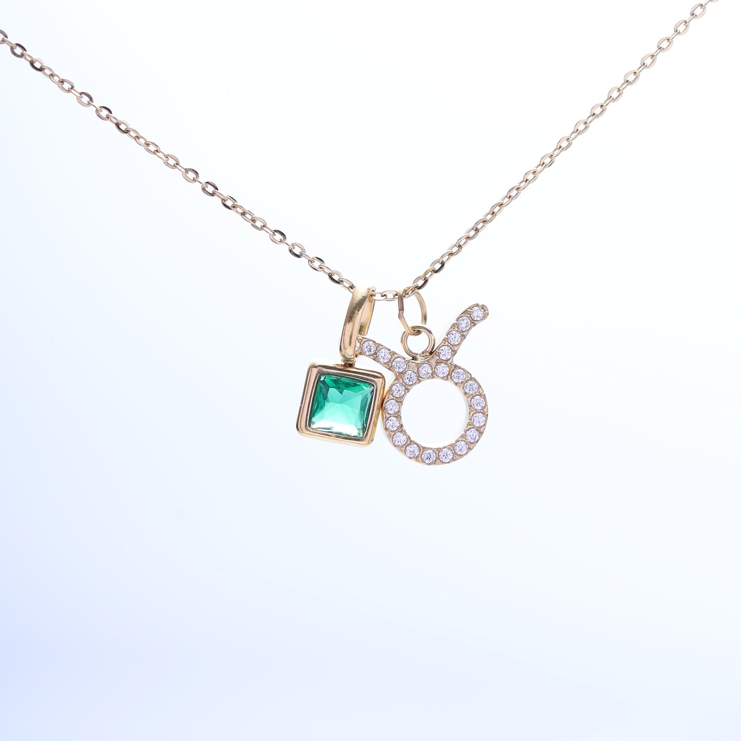 Taurus zodiac necklace with an April birthstone (clear cubic zirconia) and a pavé gold charm.