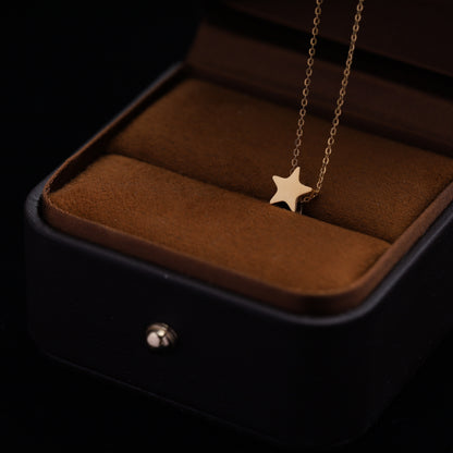Minimalist star necklace displayed in a luxury jewelry box, available in gold and silver.
